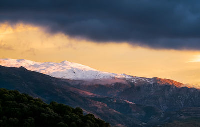 Scenic view of snowcapped mountains against sky during sunset
