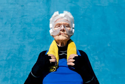 Portrait of man holding umbrella at swimming pool