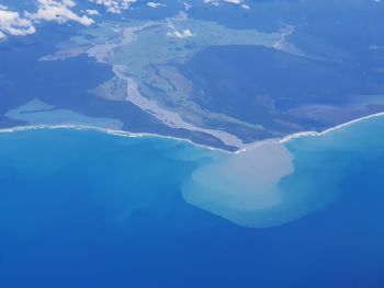 Aerial view of lake and mountains against blue sky