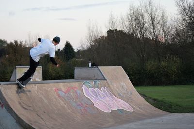 Full length of man skateboarding on skateboard against sky