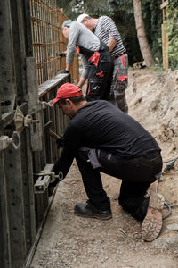 Builder with hammer man carpenter building wall, male hands with a screwdriver close-up. work with