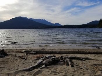 Scenic view of sea and mountains against sky