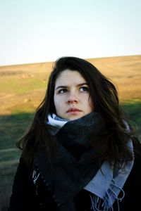 Portrait of beautiful woman standing against sky