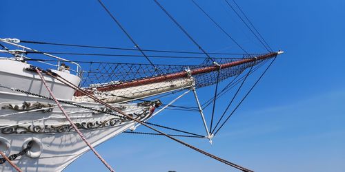 Low angle view of sailboat against blue sky