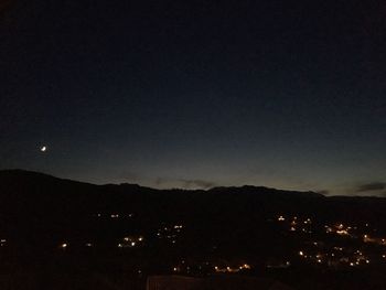 Illuminated mountains against clear sky at night