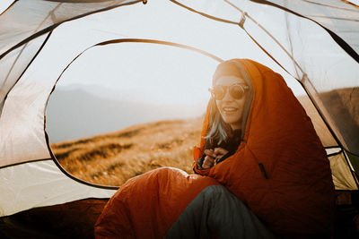 Portrait of young woman sitting in tent