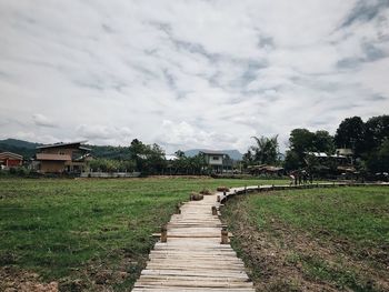 Footpath amidst buildings against sky