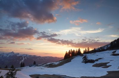 Scenic view of snow covered mountains against sky during sunset