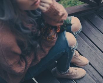 Low section of woman sitting on wooden steps