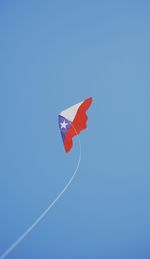 Low angle view of kite flying in clear blue sky