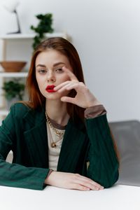 Portrait of young woman sitting on bed at home