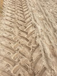 High angle view of tire tracks on sand