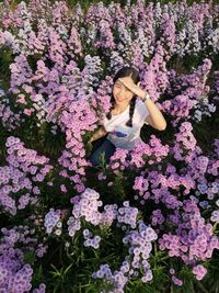 High angle portrait of woman sitting amidst flowering plants