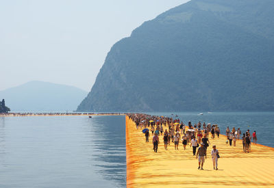 People on beach against clear sky