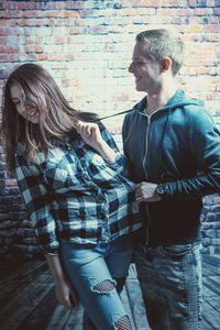 Cheerful couple against brick wall