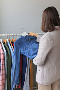 Rear view of woman standing against wall