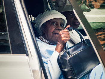 Portrait of man holding camera in car