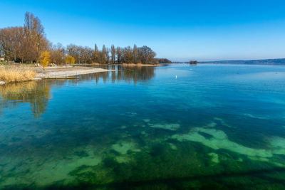 Scenic view of lake against clear blue sky