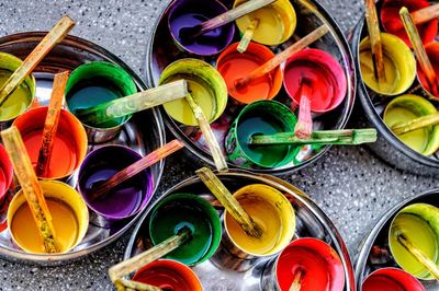 High angle view of colorful paint cans on floor