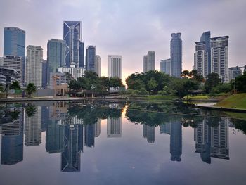 Reflection of modern buildings in city against sky