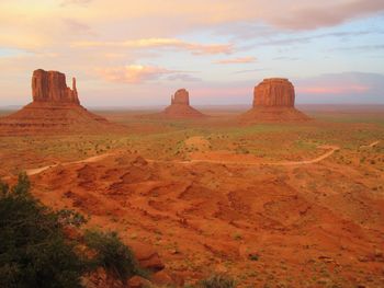 Scenic view of rock formations at monument valley against sky during sunset