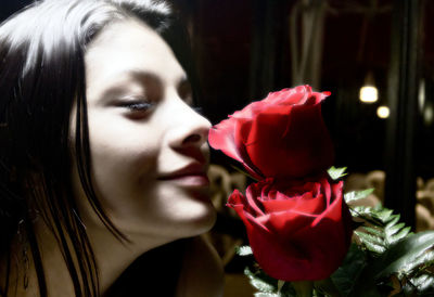 Close-up of woman with red flower