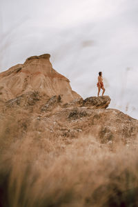 Low angle view of woman standing on mountain