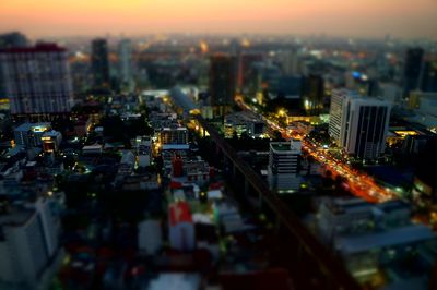 High angle view of illuminated buildings in city against sky during sunset