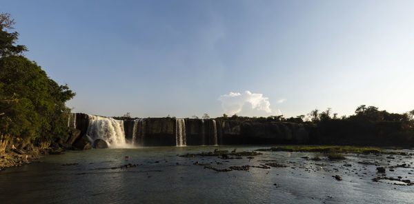 Scenic view of waterfall against sky