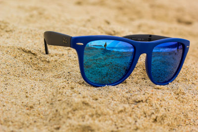 Close-up of sunglasses on beach