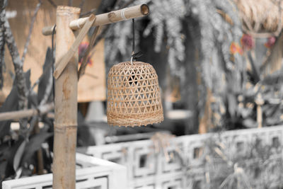 Close-up of wicker basket hanging on wood