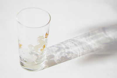 Close-up of beer glass on table against white background