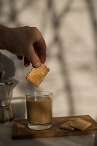 Midsection of person holding ice cream on table