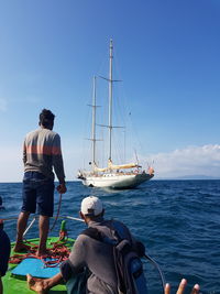 Rear view of sailboat on sea against sky