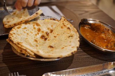 Close-up of hand in plate on table