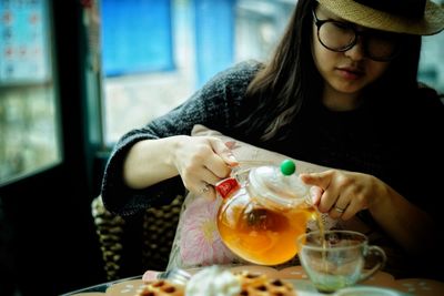 Midsection of young woman sitting at restaurant table