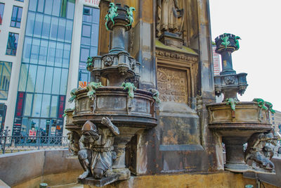 Low angle view of statue against building in city
