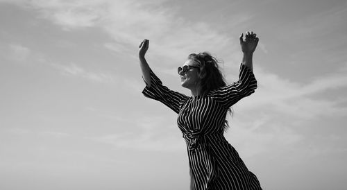 Low angle view of woman standing against sky