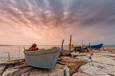 Rear view of man on beach against sky during sunset