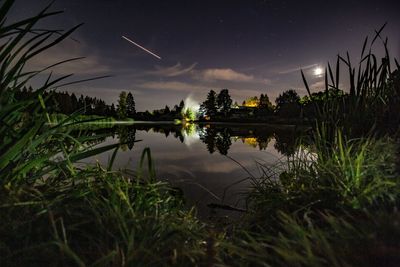 Scenic view of lake against sky at night