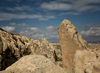 View of rock formations against cloudy sky