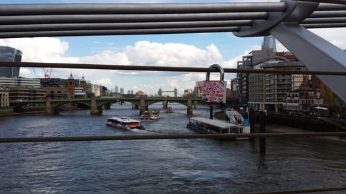 Bridge over river in city against sky