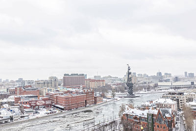 High angle view of city buildings against cloudy sky