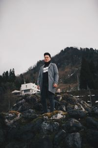 Portrait of young man standing on rock