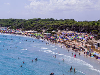 People at beach against sky