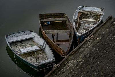 High angle view of old abandoned wooden rowboats moored in lake