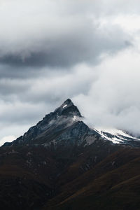 Details of snow capped mountain peak against sky