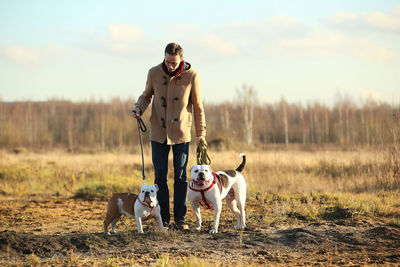 Full length of man with dogs standing on land