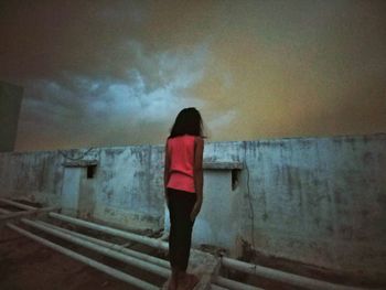 Rear view of woman standing against wall