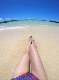 Low section of woman relaxing on beach